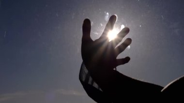 Avuç İçi Maskeli Kadın Kirli Pencereye Dokunuyor, Güneş Işıklarına Uzanıyor