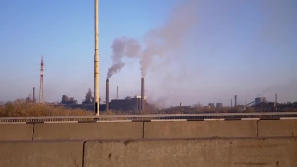 धूम्रपान धातूच्या कारखान्याच्या ठोस ब्रिज बॅकड्रॉपद्वारे कार अगोदर नोंदणी केली जाते — स्टॉक व्हिडिओ