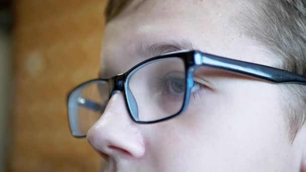 View Front Child with Glasses Kijkt naar het scherm van een TV Monitor, een PC. 4K — Stockvideo