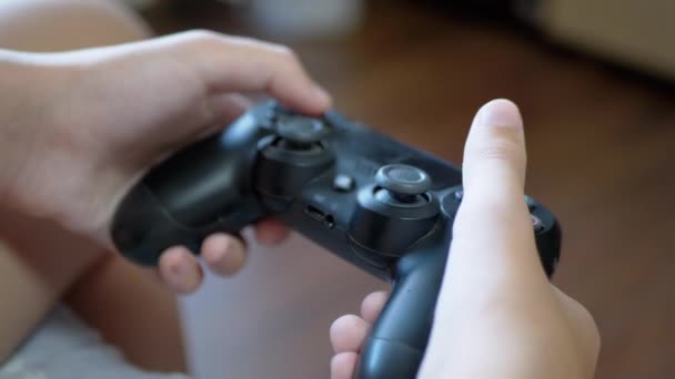 A gyermek vezeték nélküli Joystick-ot használ, a konzolon játszható játékok kezelőjét. — Stock videók