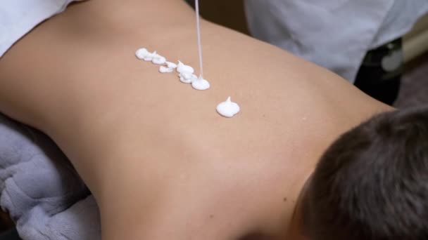 Massagetherapeut brengt de Crème terug op Kind voor een Massagesessie. Zoom — Stockvideo