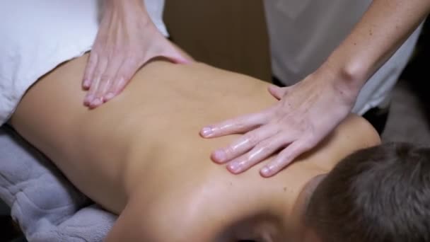 A masszőr kezei egy tinédzser hátának masszírozása, egy gyermek egy Spa szalonban. — Stock videók