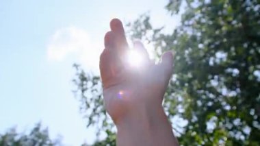 Mutlu Bir Kızın Elleri Bulanık Ağaçların Arkaplanındaki Güneşe Uzanıyor.