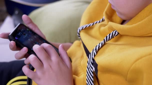 ( 영어 ) Yellow Hoodie Sits - Sofa Playing Mobile Game on Smartphone at Home — 비디오