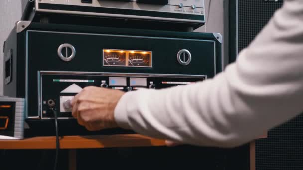 Mão Masculina Tunes Som em Retro Estéreo Power Amplificador com Iluminado no Dial — Vídeo de Stock
