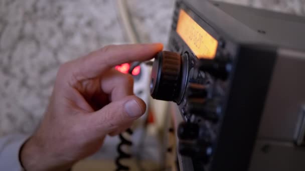 Transceptor de comunicación de radio de Tunes de mano masculina en la estación de radio estacionaria — Vídeos de Stock