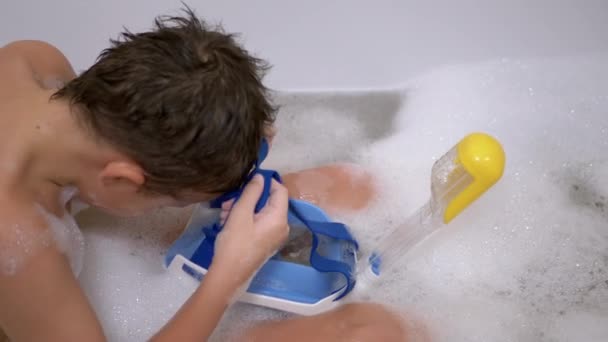 Happy Boy badet in Badewanne mit Schaum, trägt blaue Tauchermaske. Tauchen lernen — Stockvideo