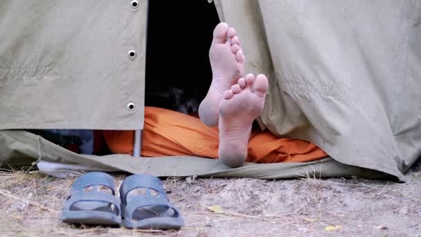 Bare Feet Mannelijke Benen gluren uit een open militaire tent in de natuur. Zoom — Stockvideo