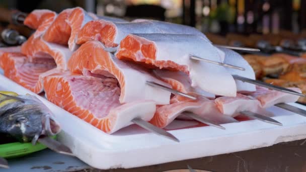 Приготовьте огромные, нарезанные кусочки лосося для жарки рыбных кебабов. Закрывай. 4K — стоковое видео
