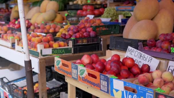 Venta de fruta fresca en cajas de madera con etiquetas de precio en un mostrador abierto en el mercado — Vídeo de stock