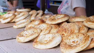 Satıcı kadın açık tezgahta haşhaş tohumlu çörek satıyor.