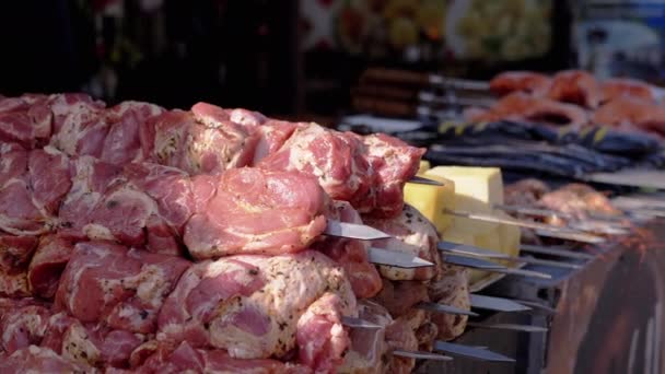 Lots Raw Pork Kebabs on a Skewer Lie on an Open Counter in the Market. Close up — Vídeo de Stock