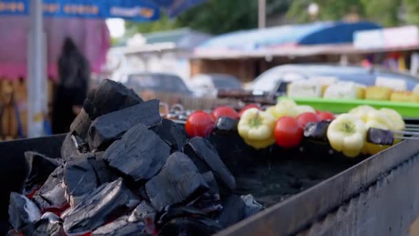 Carbón en llamas, una llama en la parrilla cerca de las verduras a la parrilla. De cerca. 4K — Vídeo de stock