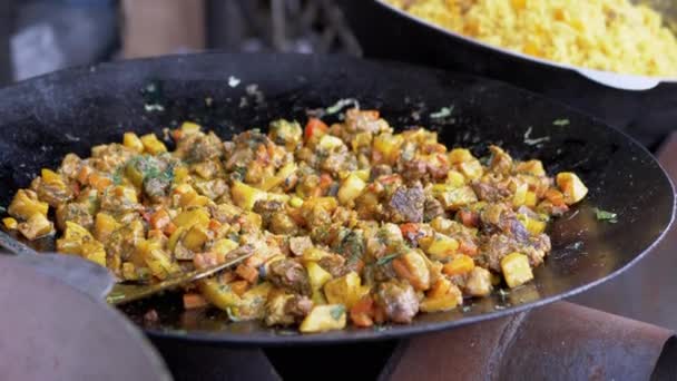 Het koken van de stoofvlees gebraden met groenten in een ketel buiten. Sluiten. — Stockvideo