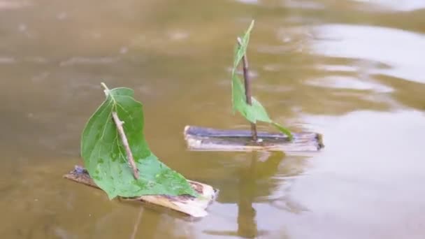 Δύο μικρά σπιτικά παιδικά ξύλινα πλοία που επιπλέουν με τον ποταμό. 4K. Κλείσε. — Αρχείο Βίντεο