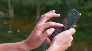 Plajda Rahatlayan Erkek Bir Mobil Uygulamada Şifreli Para Tablosu Görünüyor