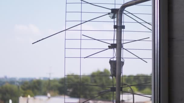 An Old, Rusty TV Antenna is Attached to a Bracket Outside the Window. Zoom — Stockvideo