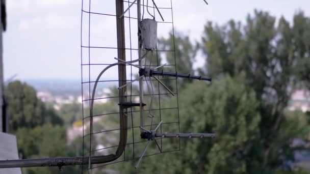 An Old, Rusty TV Antenna is Attached to a Bracket Outside the Window. Zoom — Vídeo de Stock