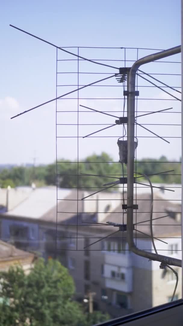 Ancienne antenne de télévision rouillée est attachée à une fenêtre extérieure de support. 4K. Gros plan — Video