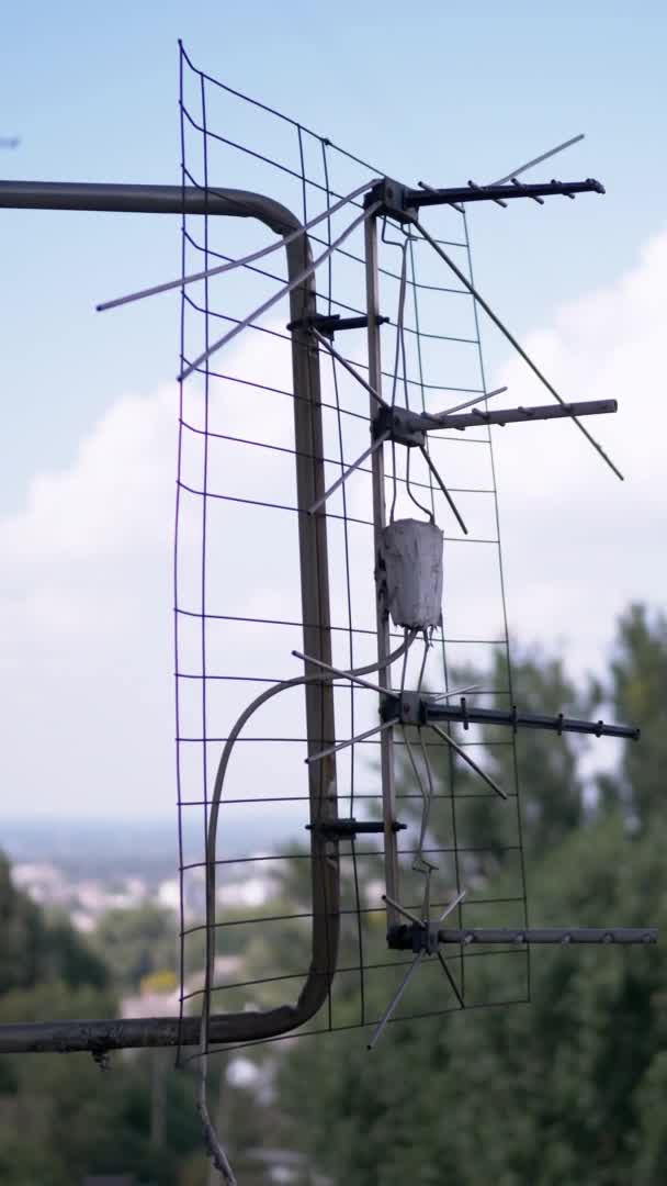 Stara, zardzewiała antena TV jest przymocowana do wspornika za oknem. 4K. Zamknij się. — Wideo stockowe