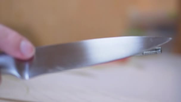 Женские руки точат нож на старом, грязном, царапанном стальном прутике на кухне — стоковое видео