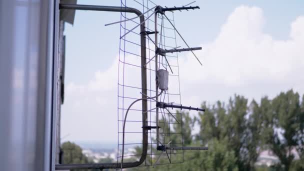 Uma antena de TV velha e enferrujada é anexada a um suporte fora da janela. 4K — Vídeo de Stock