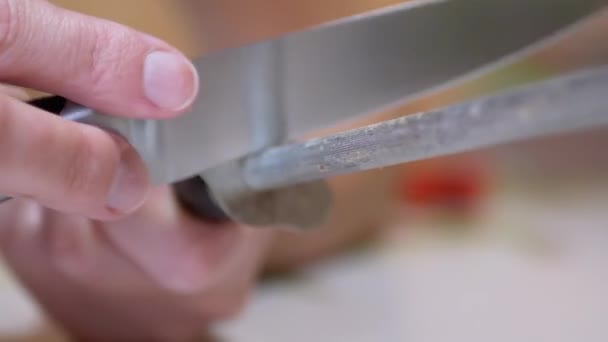 Le mani femminili affilano un coltello su vecchio, sporco, graffiato un bastone d'acciaio in cucina — Video Stock