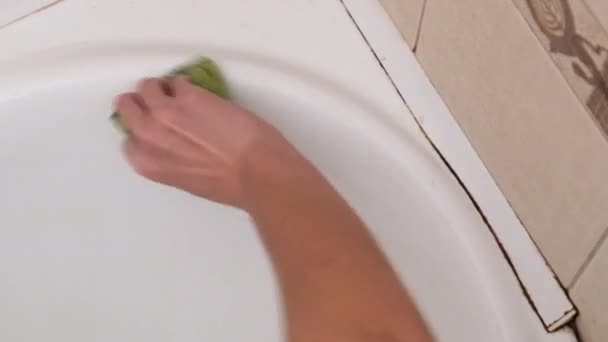 Nő mossa, tisztítja, dörzsöli a piszkos fürdőszobát egy szivaccsal szappannal és habbal — Stock videók