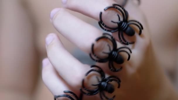 Dítě vesele vrtí prsty, hraje si s prsteny na hračky pavouků — Stock video