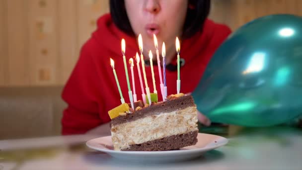 Szczęśliwa kobieta zdmuchuje świeczki na urodzinowym kawałku ciasta. Zwolniony ruch — Wideo stockowe