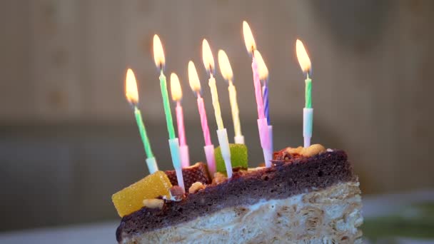 Soplando velas navideñas en un pedazo de pastel de cumpleaños. De cerca. — Vídeo de stock