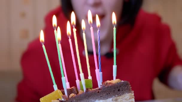 Feliz fêmea sopra velas em um pedaço de bolo de aniversário. Zoom. Fechar — Vídeo de Stock