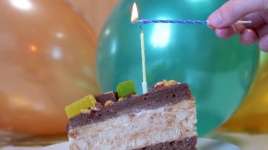 Dişi El Işıkları Bir Mum Bir Parça Çikolatalı Pastada. Büyüt