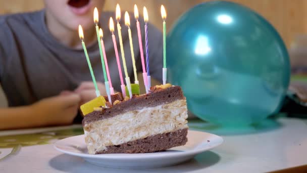 Happy Child souffle les bougies le jour de l'anniversaire morceau de gâteau. 4K. Gros plan — Video