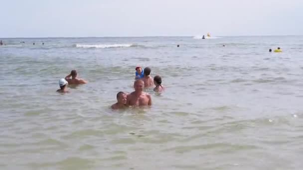 Vader en Zoon Zwemmen in de open zee tegen de achtergrond van Zwemmende Toeristen — Stockvideo