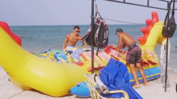 Workers at the Seaside Put Life Jackets on an Inflatable Banana. 4K. Close up — Stockvideo