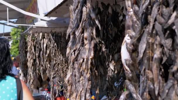 Pescado pequeño seco, Gobies colgando de ganchos en los puestos abiertos del mercado callejero — Vídeo de stock