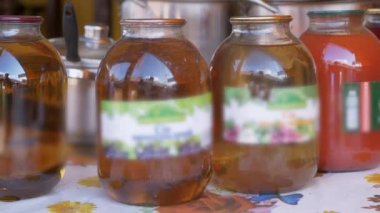 Sale of Canned Apple and Carrot Juice in Glass Jars on Open Counters