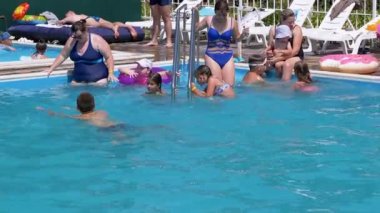 Mother and Children Swim in Transparent Turquoise Pool at the Hotel in Resort
