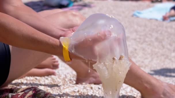 Las manos masculinas sostienen una enorme medusa marina. De cerca. Acercar. Moción lenta — Vídeo de stock