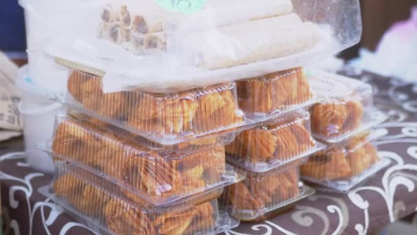 在市场上的露天柜台上出售塑胶盒中的甜糕点 — 图库视频影像
