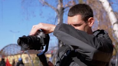Fotoğrafçı, kamerayı ve kamerayı dışarı çıkmadan önce bir tripoda ayarlar.