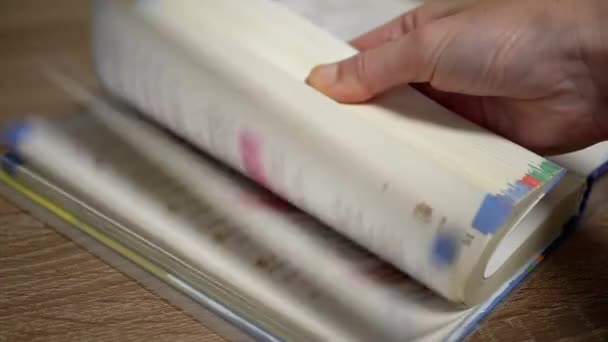 Eine unkenntliche Person blättert schnell durch die Seiten eines Buches. Zeitlupe — Stockvideo