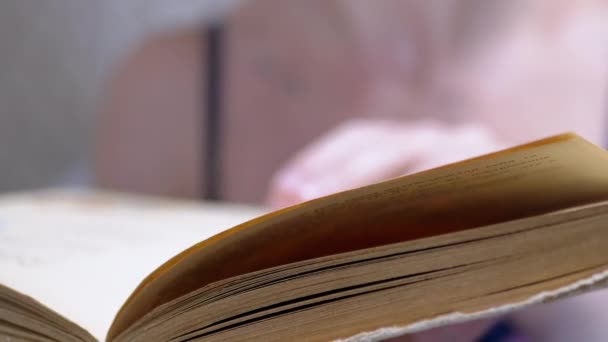 A Female Quickly Flips Through the Pages of a Shabby Old Book. 4K. Close up — Wideo stockowe