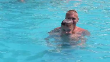 Happy Smiling Father with Son Swim in Open Transparent Swimming Pool. Close up