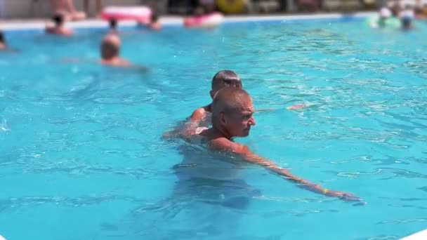Happy Smiling Father with Son Swim in Open Transparent Swimming Pool. Close up — Stockvideo