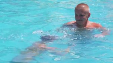 Happy Smiling Father with Son Swim in Open Transparent Swimming Pool. Close up