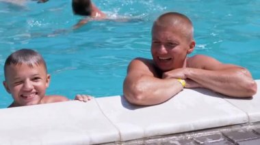 Funny Laughing Father with Son Swim in Open Transparent Swimming Pool.