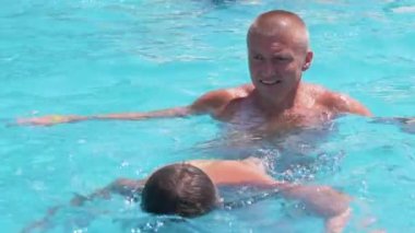 Happy Smiling Father with Son Swim in Open Transparent Swimming Pool. Close up