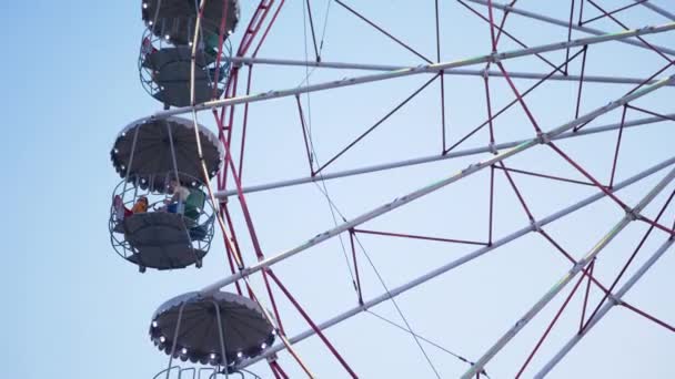 Rotating Ferris Wheel at Sunset in Moon Park with Flickering Lights on Booths — Video Stock